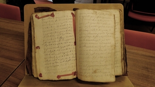 Vieux registre ouvert sur une double page et déposé sur un lutrin. - Agrandir l'image (fenêtre modale)