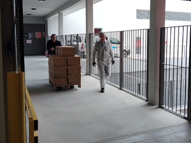 Agents déplaçant une palette de cartons vers l'entrée d'un bâtiment - Agrandir l'image, .JPG 552,9 KB (fenêtre modale)