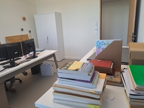Vue sur un bureau doté d'un équipement informatique, des ouvrages en premier plan - Agrandir l'image (fenêtre modale)