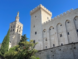 Bâtiment médiéval de style gothique comportant une tour crénelée, à sa gauche un édifice religieux - Agrandir l'image (fenêtre modale)
