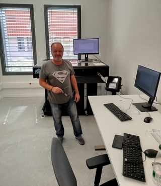 Homme dans une salle équipée de matériel informatique et d'un numériseur - Agrandir l'image (fenêtre modale)