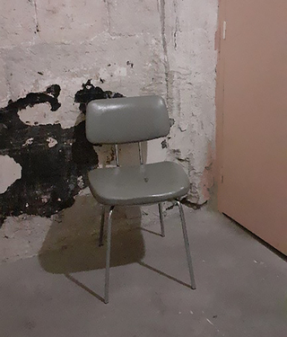 Vieille chaise de bureau revêtement skaï gris et pieds métal. 
