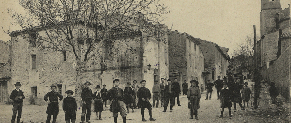 Carte postale en noir et blanc de l'avenue de Modène à Saint-Pierre-de-Vassols avec un groupe d'enfants dans la rue.