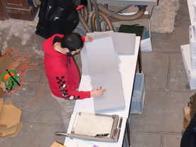 Vue d'un point élevé sur du personnel assurant le conditionnement d'archives dans un ancien magasin avec des rayonnages en bois - Agrandir l'image, .JPG 8,6 MB (fenêtre modale)
