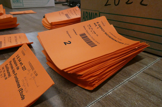 Ensemble de fiches orange sur lesquelles figurent des cotes de documents, des emplacements et l'identité de l'emprunteur - Agrandir l'image (fenêtre modale)