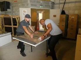 Deux hommes protègent un tiroir avec du carton et le filment. - Agrandir l'image, .JPG 776,8 KB (fenêtre modale)